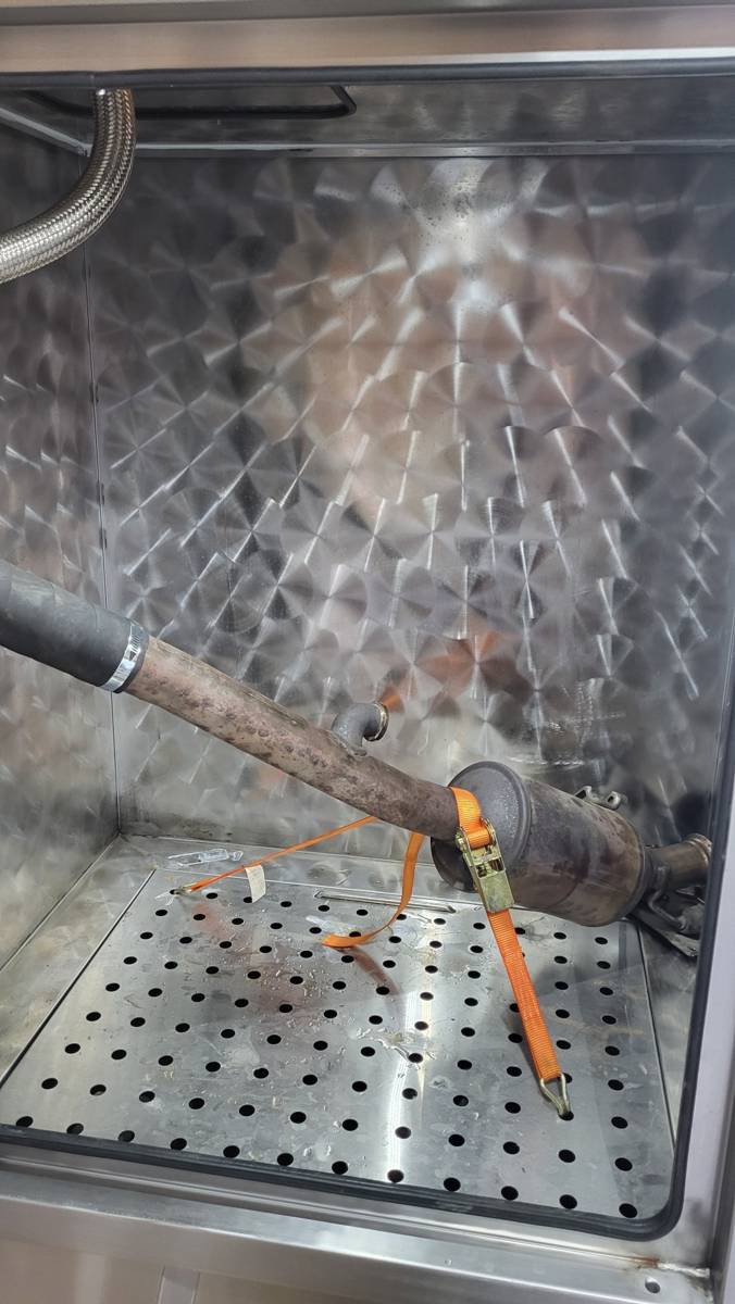DPF filter being cleaned inside MET cleaning chamber using pressurized water system