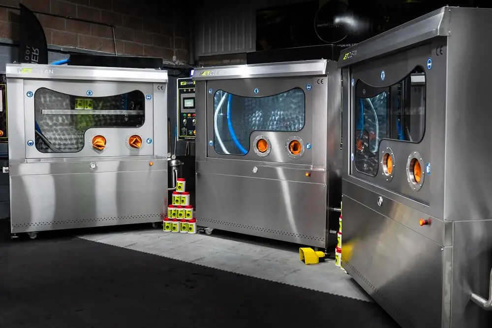 Three stainless steel DPF cleaning machines in a workshop.
